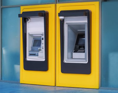 ATMs are built into the wall of the bank building. The concept of secure and safety transactions and countering the threats of scammers such as skimmers