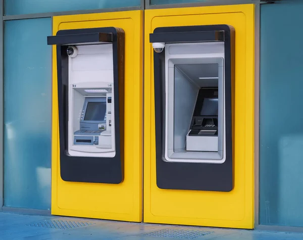 ATMs are built into the wall of the bank building. The concept of secure and safety transactions and countering the threats of scammers such as skimmers
