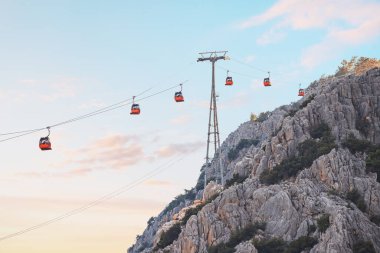 Cable car or ropeway carries tourists in closed gondolas to a viewing platform high in the mountains. Travel landmarks and transport infrastructure
