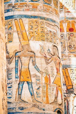 hieroglyphs and drawings of pharaohs carved in sandstone column in Karnak temple in Luxor. Egyptian heritage and history concept