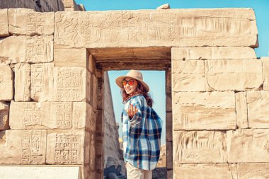 A female traveler explores the ruins of the ancient Karnak temple in the city of Luxor in Egypt. Wanderlust and vacation