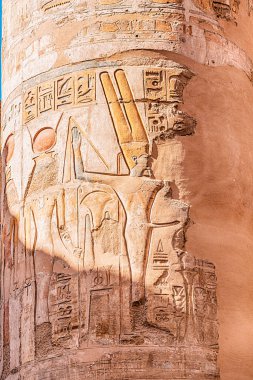 hieroglyphs and drawings of pharaohs carved in sandstone column in Karnak temple in Luxor. Egyptian heritage and history concept