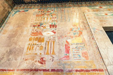 Hieroglyphs and paintings carved in sandstone columns in Hatshepsut temple in Luxor. Egyptian heritage and civilization concept