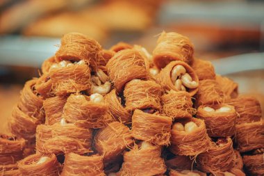 Kadayif traditional ottoman and arabic dessert with sugar noodles and nuts filling. Pastry and turkish baklava for sale