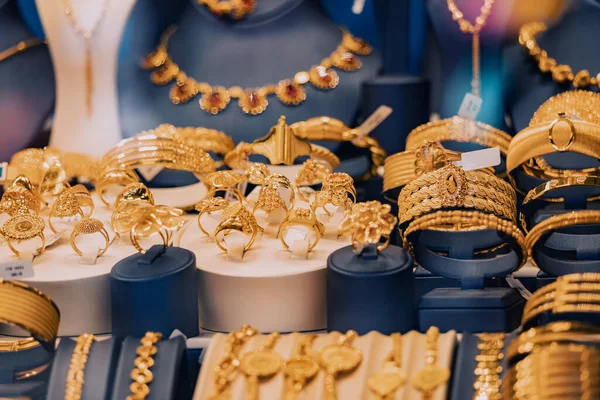 A jewelry store showcase with golden jewelry, bracelets and rings. The concept of investments and savings with gold.
