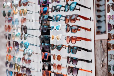 Sunglasses on the shelf in the store are for sale. UV protection and fashion accessory