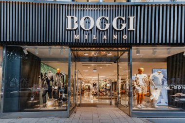 21 Temmuz 2022, Düsseldorf, Almanya: Ünlü zincir moda mağazası Zegna girişi sergilenmektedir. İnsanlar vitrinden geçiyor.