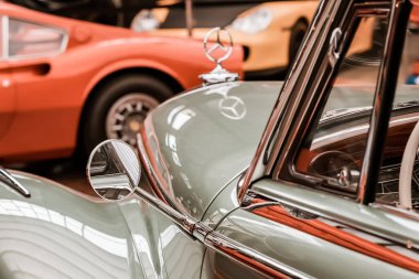 10 Temmuz 2022, Antalya, Türkiye: Müzede veya otomobil fuarında lüks bir retro arabanın önünde Mercedes-Benz logosu