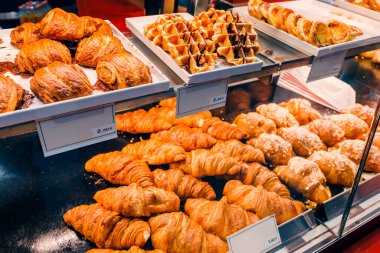 Kruvasanlar ve diğer börekler dükkan vitrininde satılıyor. Tatlı dişleri ve şekerleme konsepti