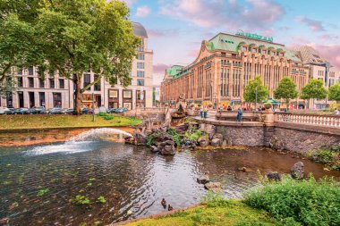 21 Temmuz 2022, Düsseldorf, Almanya: Kaufhof Galerisi yakınlarındaki Konigsallee kanalında Triton heykeli ve çeşmesi