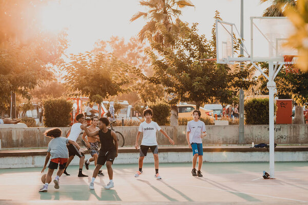 18 июля 2022 года, Анталья, Турция: Молодые люди и подростки играют в уличный баскетбол на детской площадке в парке. Спорт и фитнес