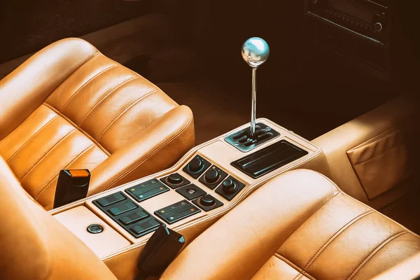 the gearshift lever in the interior of a luxury car with leather upholstery seats