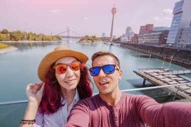 Birkaç arkadaş, Dusseldorf 'un en büyük eğlence merkezlerinden biri olan RheinTurm Tv-Tower' ın arka planında selfie çekiyorlar.