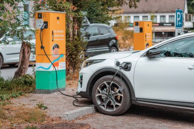 22 Temmuz 2022, Düsseldorf, Almanya: modern elektrikli KIA arabası Neanderthal Müzesi 'nin otoparkında şarj edilir. Çevresel farkındalık ve yeşil ulaşım