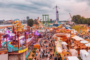 22 Temmuz 2022, Düsseldorf, Almanya: Dusseldorf 'ta Ren nehrinin kıyısında düzenlenen geleneksel bir festivalde turist ve insan kalabalıklarının hava manzarası ve eğlence fuarı ve pek çok lokanta