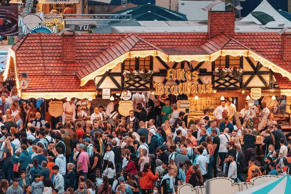 22 Temmuz 2022, Düsseldorf, Almanya: Brathaus 'un yakınlarında yürüyen turist kalabalığı bira ve geleneksel sucuk satıyor