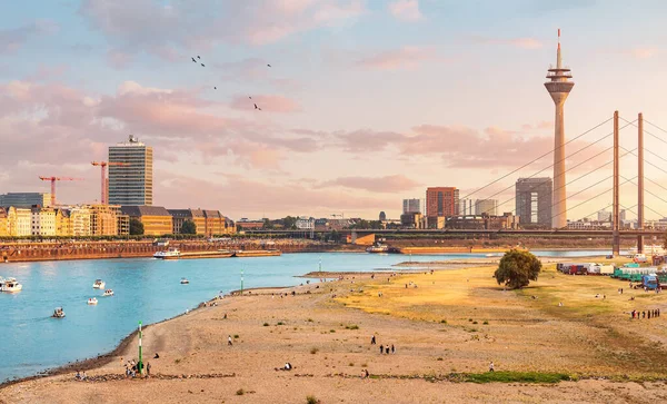 Panoramic view of Rheinkniebrucke Bridge and Tv tower in Dusseldorf city and transportation water way of the whole Germany - Rhine River, along which large barges and small ships are sailing