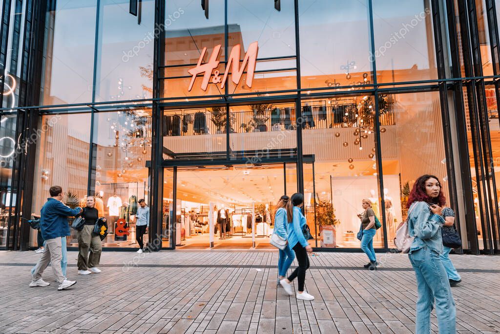 21 July 2022, Dusseldorf, Germany: Famous chain fashion shop H and M entrance with clothes on display.