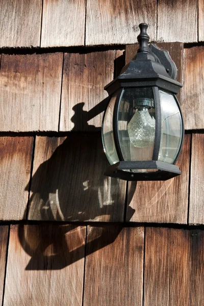 Old Lamp on a Wooden Wall with Shadow — Stock Photo, Image