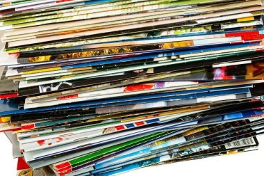 Açık arkaplanda eski, renkli dergiler yığını.