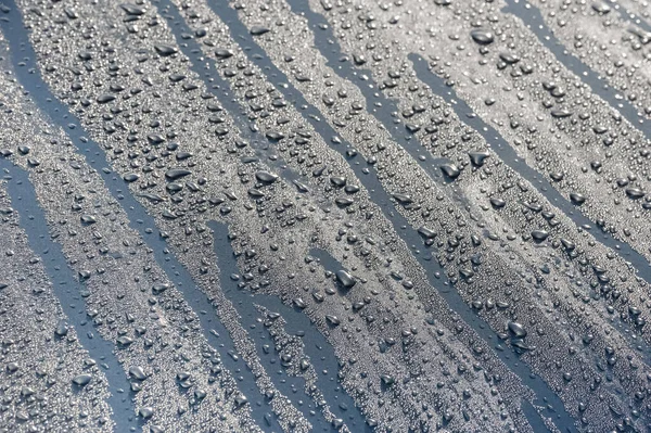 青い空の下で金属製の車両フードに雨が降り — ストック写真