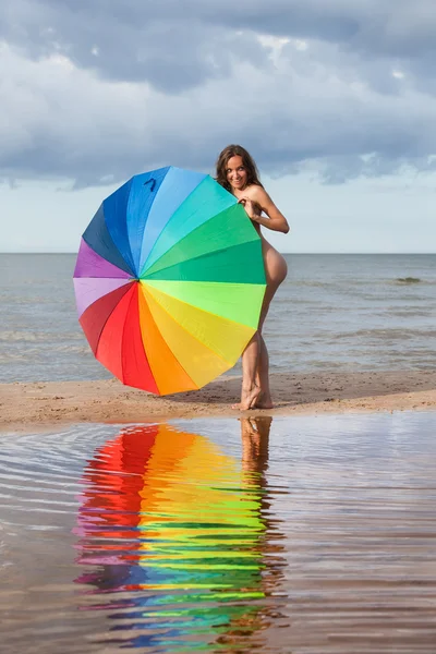 Menina nua com um guarda-chuva colorido — Fotografia de Stock