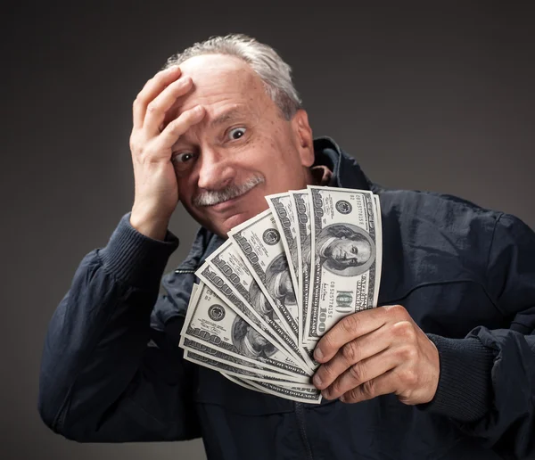 Old man holding group of dollar bills — Stock Photo, Image