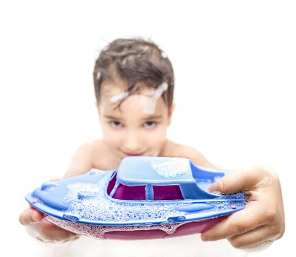 Niño jugando en el baño con un barco de juguete — Foto de Stock