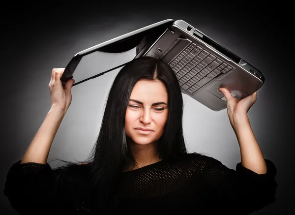 Jonge vrouw met een laptop op haar hoofd — Stockfoto