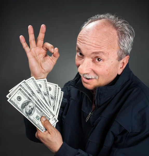 Elderly man showing fan of money — Stock Photo, Image