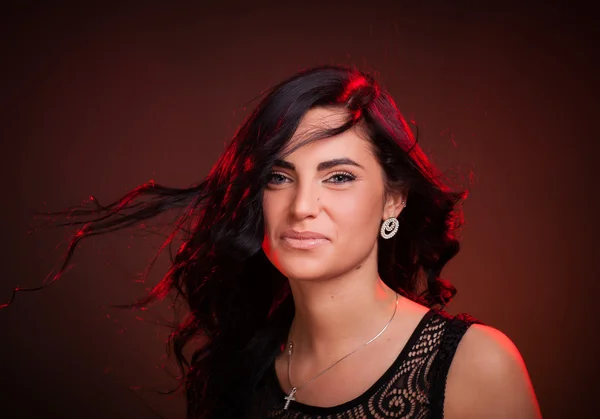 Smiling woman with hair blowing on wind — Stock Photo, Image