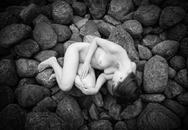 kayaların üzerinde yatan genç womanl