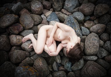 kayaların üzerinde yatan genç womanl