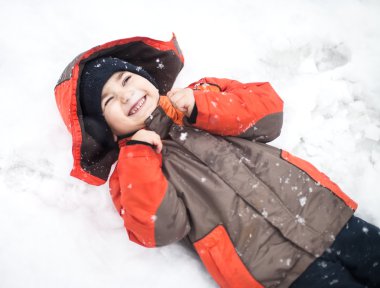 Çocuk kar altında yer alır.