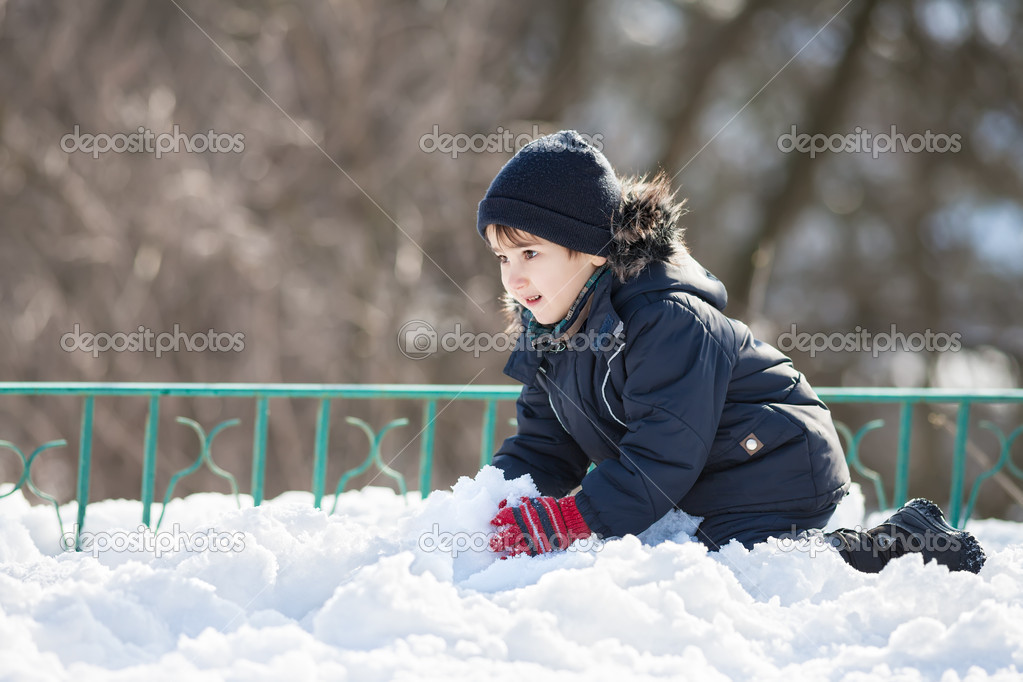 Cute boy playing with snow
