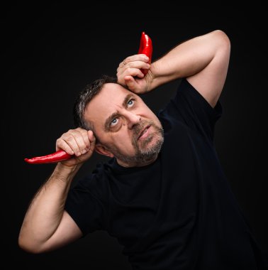 yaşlı adam holding iki red hot chili peppers