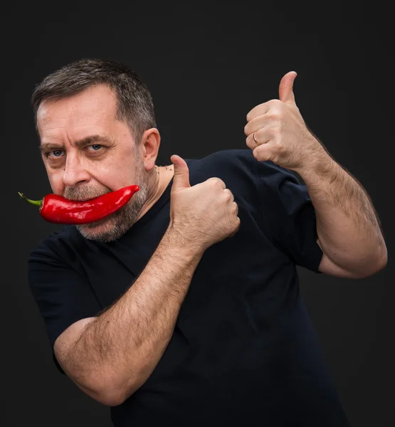 Homme âgé avec du poivron rouge dans la bouche — Photo