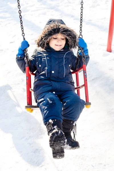 Kid swingen in de sneeuw — Stockfoto