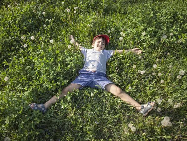 Rapaz deitado na relva — Fotografia de Stock