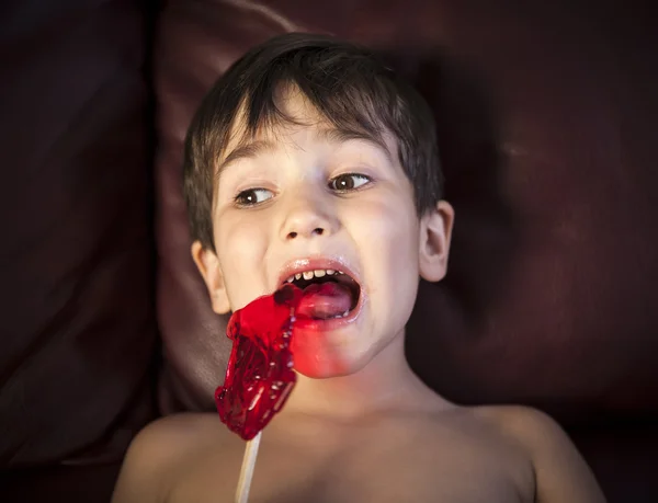 Мальчик, съедающий Lollipop — стоковое фото