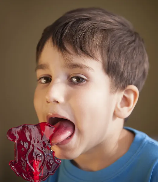 Chico comiendo una piruleta —  Fotos de Stock