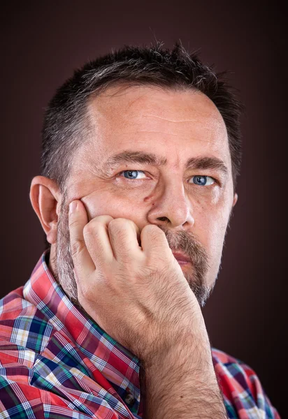 Doordachte oudere man met hand in de buurt van het gezicht — Stockfoto