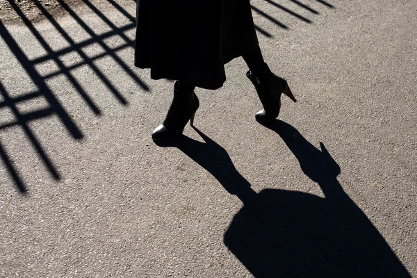 Kadın bacakları asfalt üzerinde gölge — Stok fotoğraf