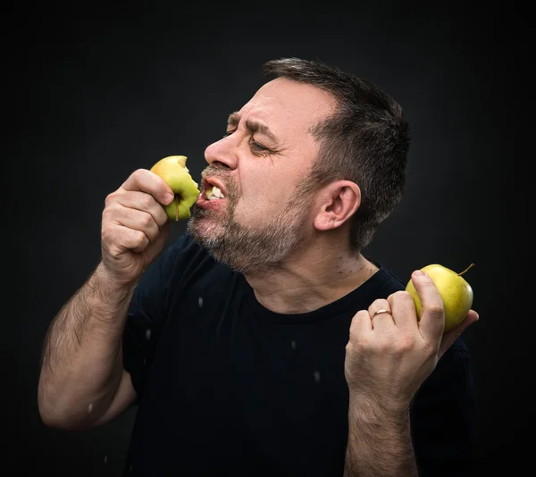 Homem com apetite comer uma maçã verde — Fotografia de Stock