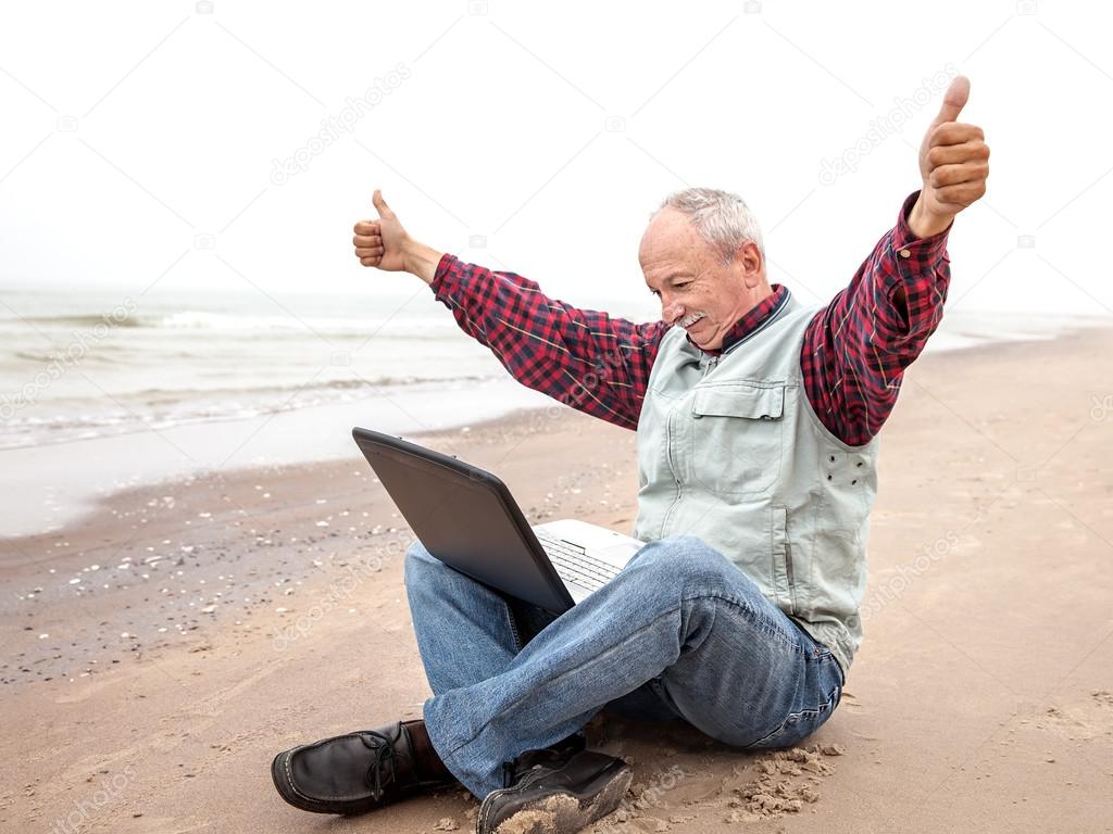 Old man with notebook on beach