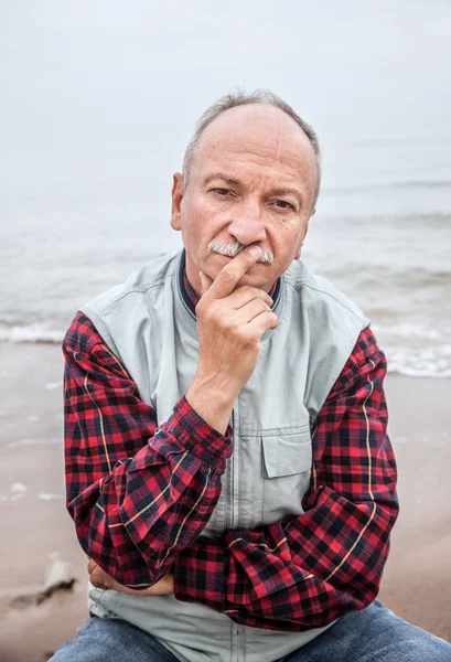 Starszy mężczyzna na plaży w mglisty dzień — Zdjęcie stockowe