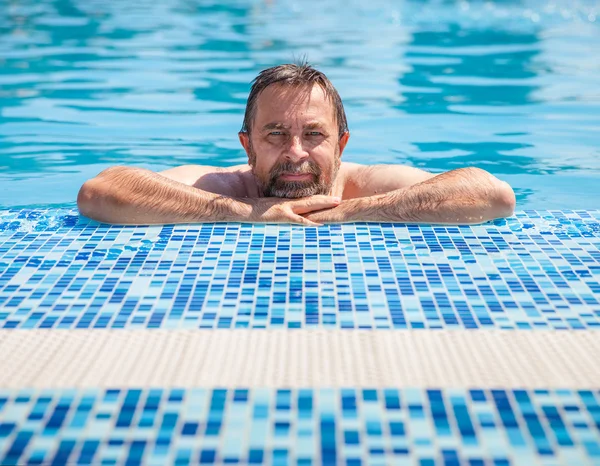 Man van middelbare leeftijd in een zwembad — Stockfoto