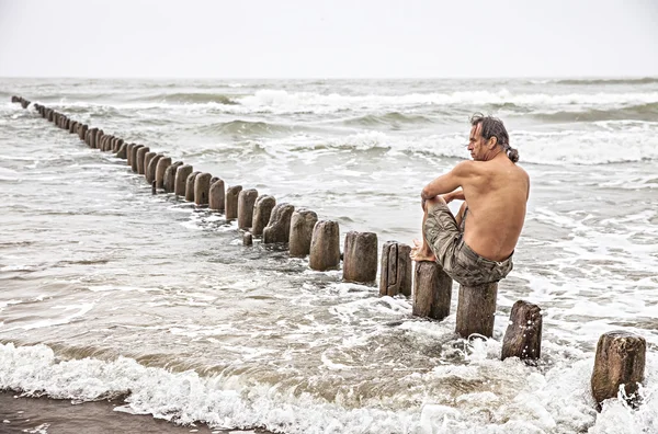 海のそばに座っている中年の男 — ストック写真