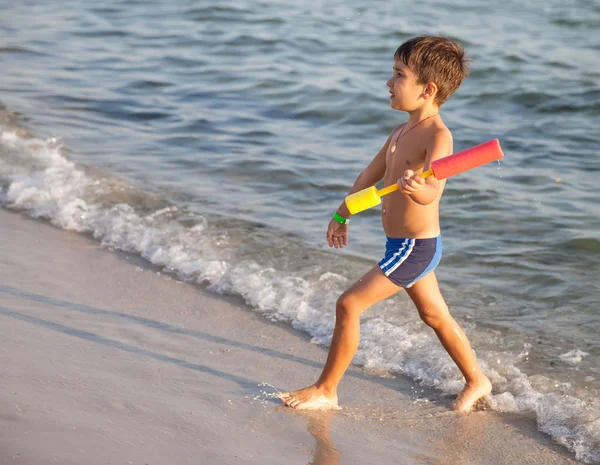 Kleine jongen wandelen door de zee — Stockfoto