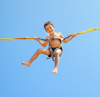 Boy jumping on trampoline clipart